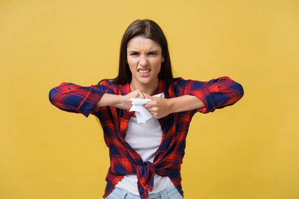 Aggressivo giovane donna caucasica strappi contratto o foglio bianco di carta. Isolato su sfondo giallo . — Foto Stock