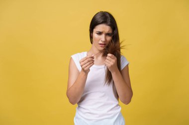 Uzun saçlarını saç bakım sorunları bozuk bölme ucunda görünümlü tutan kadın el.