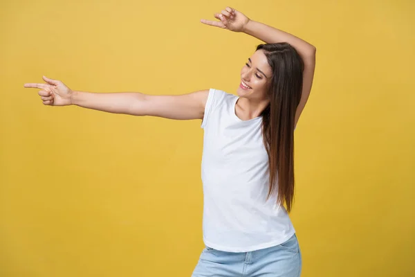 Perfil de una mujer apuntando a un espacio de copia para un anuncio aislado sobre un fondo amarillo —  Fotos de Stock