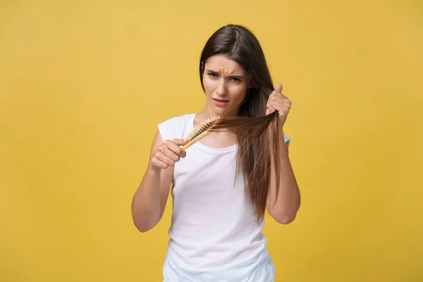 La ragazza sta tenendo un pettine con i capelli caduti. Il concetto di salute dei capelli . — Foto Stock