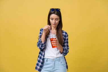 Holding ve rahat kıyafetler içinde soğuk içki içecek içme genç kadın. güzel kız mutlu gülen kameraya bakarak gülen.