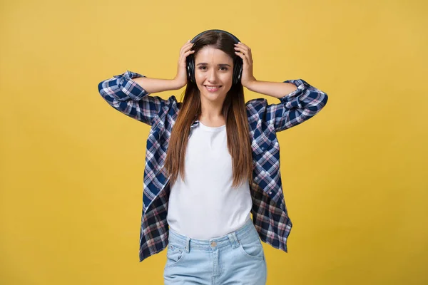 Mulher bonita em fones de ouvido ouvindo música e dançando em fundo amarelo . — Fotografia de Stock