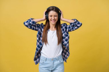 Müzik dinlemek için telefon kullanan genç bir kadın..