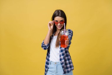 Holding ve rahat kıyafetler içinde soğuk içki içecek içme genç kadın. güzel kız mutlu gülen kameraya bakarak gülen