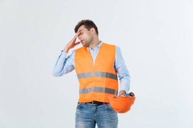 Genç giyen mimar kıyafeti ve kızgın surat, negatif antipati duygu ile kask adam. Öfkeli ve ret kavramı