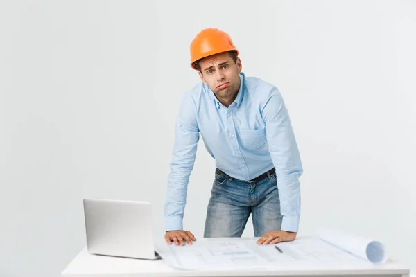 Joven hombre con traje de arquitecto y casco con la cara enojada, negativa desagrado emoción. Enfadado y concepto de rechazo — Foto de Stock