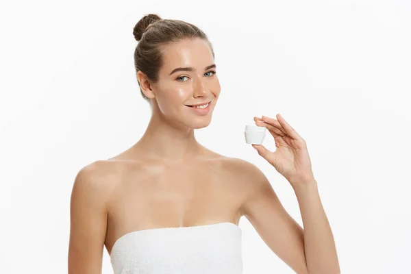 美容青春肌肤护理理念-美丽的白种女人脸上的肖像持有和呈现奶油管产品。美丽的水疗模型女孩与完美的新鲜干净的皮肤白色背景 — 图库照片