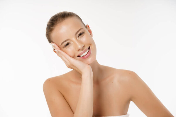 Beautiful young woman with clean fresh perfect skin. Portrait of model with natural nude make up, with towel on the body. Facial treatment. Cosmetology, beauty and spa. Skin care