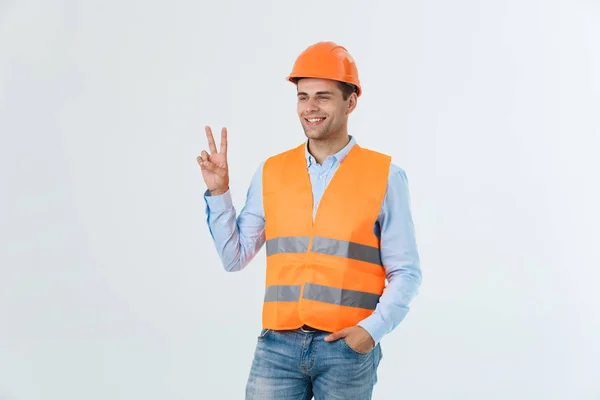 Jeune ouvrier avec casque heureux et comptant deux avec les doigts sur fond blanc — Photo