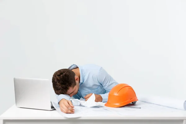 Young attractive engineer man feeling tired at work place — Stock Photo, Image