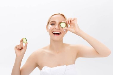 Güzel kadının temiz sağlıklı cilt ve salatalık dilimleri ile yakın çekim yüz. Beyaz izole.