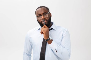 Elindeki kalemle gri takım düşüncesinde dalgın bir Afrikalı-Amerikalı işadamı portresi.