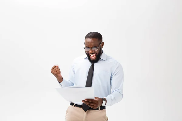 Lycklig African American man hålla documaent papper över isolerade vit bakgrund med en överraskning och chock ansikte uttryck — Stockfoto