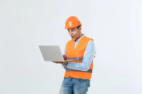 Handsome young engineer man over grey wearing safety helmet with shocked surprise face. — Stock Photo, Image