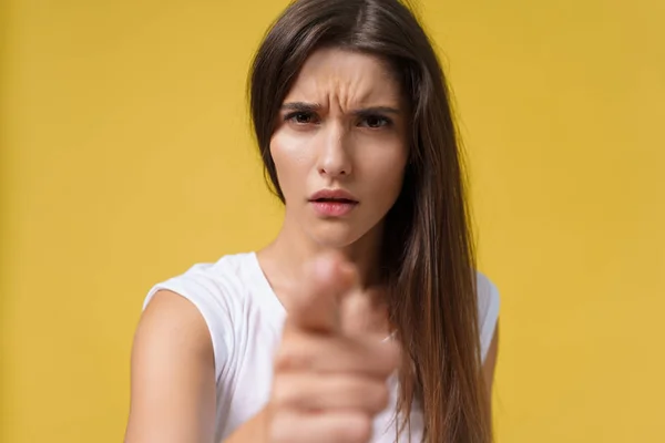 Retrato de cerca de una atractiva joven caucásica con una cara enojada. mirando furioso y loco mostrando los dientes y señalando con el dedo a la cámara. Expresiones faciales y emociones humanas —  Fotos de Stock