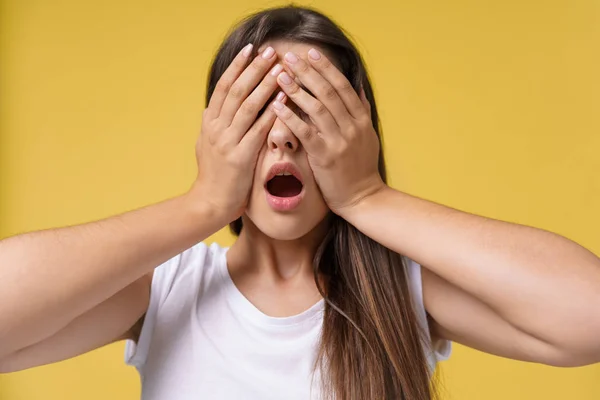 Happy surprised excited woman covering with hands her eye with blank copy space,Portrait beautiful woman. Positive human emotion expression,isolated on yellow background — Stock Photo, Image
