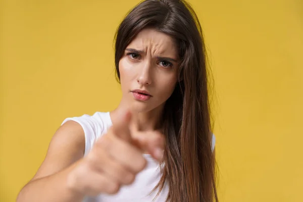 Close up portrait of an attractive young caucasian woman with an angry face. looking furious and crazy showing teeth and pointing finger at the camera. Human facial expressions and emotions — Stock Photo, Image