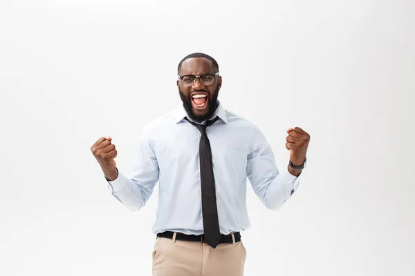 Glada afrikanska affärsman bära företagets grå skjorta och svart slips stansning luften med armarna nävar i luften, leende och skriker i segrande framgång för hans affär — Stockfoto