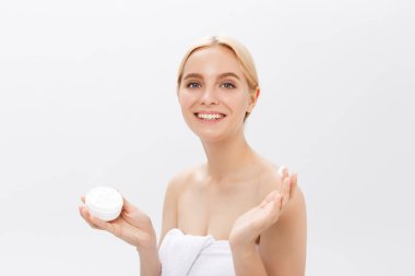 Yüz kremini uygulamadan bir gülen güzel yarı çıplak kadın güzellik portresi kapatmak ve seyir uzağa beyaz arka plan üzerinde izole.