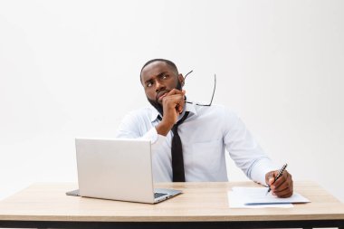 Düşünceli genç Afro-Amerikan iş adamı dizüstü bilgisayarla çalışıyor.