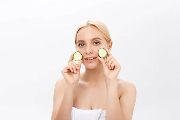 Beautiful woman holding slices of cucumber in front of her eyes — Stock Photo, Image