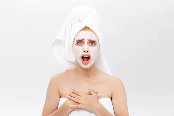 Удивлённая молодая женщина в косметической маске для лица — стоковое фото