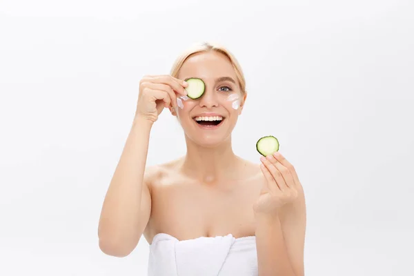 Portrait de la fille ludique couvrant un oeil par une tranche d'un concombre, isolé sur blanc . — Photo