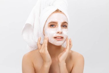 yakın çekim güzel bir kadın yüzü açık renkli kozmetik nemlendirici krem uygulayarak.