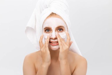 yakın çekim güzel bir kadın yüzü açık renkli kozmetik nemlendirici krem uygulayarak.