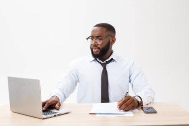 İş ve başarı. Dizüstü bilgisayar uzak iş için ciddi bir yüz ifadesiyle ekrana bakarak kullanan resmi elbise giymiş yakışıklı başarılı Afrikalı-Amerikalı adam.