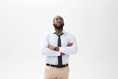 Kızgın ya da rahatsız genç Afro-Amerikan adam beyaz polo gömlek ile memnun ifade kameraya bakarak portresi. Negatif insan ifadeleri, duygular, duygular. Beden dili.