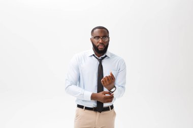 Kızgın ya da rahatsız genç Afro-Amerikan adam beyaz polo gömlek ile memnun ifade kameraya bakarak portresi. Negatif insan ifadeleri, duygular, duygular. Beden dili.