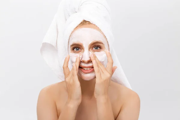 Close-up bela mulher aplicando creme cosmético hidratante no rosto no fundo claro . — Fotografia de Stock