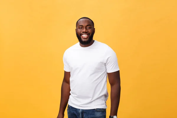 Portrait of delighted African American male with positive smile, white perfect teeth, looks happily at camera, being successful enterpreneur, wears white t shirt.