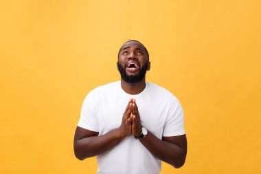 Stüdyo portre Afrikalı-Amerikalı gencin Beyaz gömlekli, ellerimi dua düşünceli şüpheci ifade yüzünde, kameraya bakarak, bir şeyden şüphelenen. Beden dili.