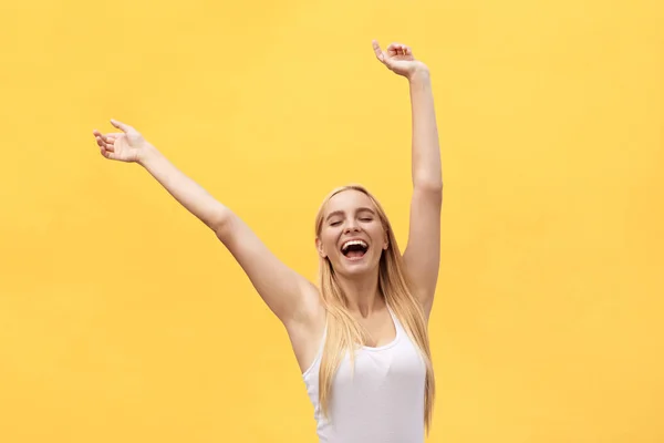 Jovem menina feliz bonita com a mão no retrato de ar isolado no fundo amarelo . — Fotografia de Stock