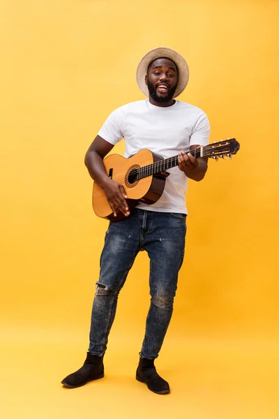 Foto completa de homem artístico animado tocando sua guitarra em suíte casual. Isolado sobre fundo amarelo . — Fotografia de Stock