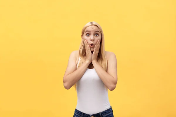 Sorprendido feliz hermosa mujer mirando a la cámara en la emoción. Aislado sobre fondo amarillo —  Fotos de Stock