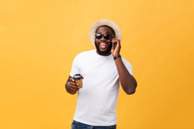 Cep telefonu ve take away kahve fincanı ile yakışıklı Afrikalı-Amerikalı. Sarı altın arka plan üzerinde izole.