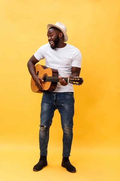 Foto completa do homem artístico animado tocando sua guitarra. Isolado sobre fundo amarelo . — Fotografia de Stock