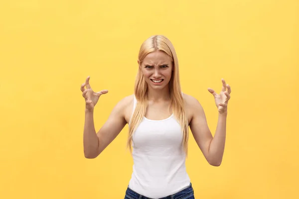 Retrato de una mujer enojada irritada con las manos levantadas gritando a la cámara aislada sobre fondo amarillo — Foto de Stock