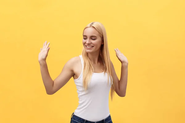 Retrato de una alegre estudiante feliz mientras baila aislada sobre fondo amarillo —  Fotos de Stock