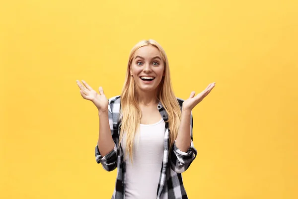 Portret van verrast jonge vrouw in een wit overhemd reputatie voor gele muur. — Stockfoto