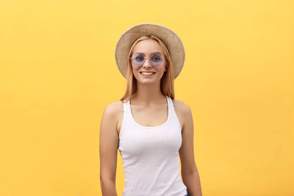 Happy stylish modern woman with modern shaped sunglasses laughing looking at you camera isolated on yellow background. Happiness concept