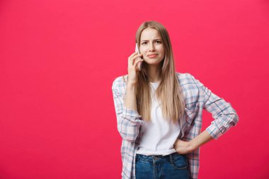 Telefonla arama ve pembe bir arka plan üzerinde çılgın görünümlü sıkılmış kız