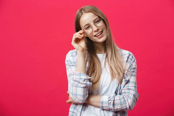 Retrato de uma mulher casual em óculos olhando para a câmera isolada em um fundo rosa — Fotografia de Stock