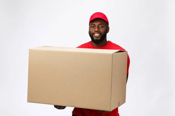 Delivery Concept - Schöner afroamerikanischer Zusteller mit Paketkasten. Isoliert auf grauem Studiohintergrund. Kopierraum — Stockfoto