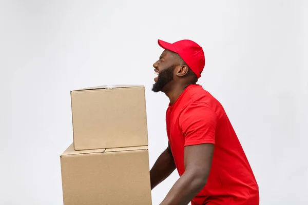 Porträt eines afrikanisch-amerikanischen Mannes im roten Hemd. er hebt schwere Gewichtsboxen gegen einen isolierten auf weißem Hintergrund. — Stockfoto