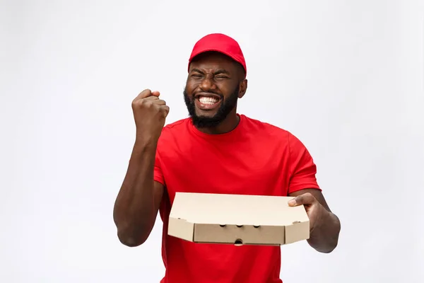 赤いTシャツとキャップの配達サービスから幸せなアフリカ系アメリカ人の男性の写真食べ物の注文を与え、白い背景に隔離されたピザボックスを保持 — ストック写真