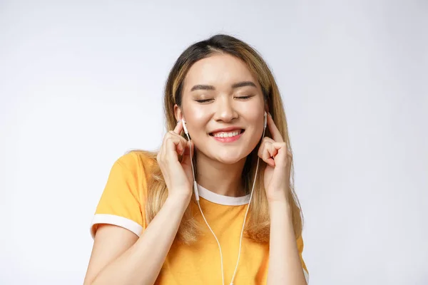 Портрет щасливі азіатських молоду жінку, слухати музику з навушників. — стокове фото